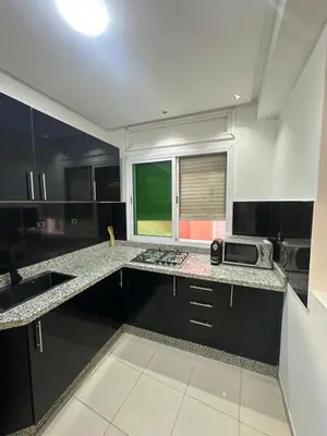 a kitchen with black and white counters and a window at Centre ville T3 jacuzzi privé 2 min de la gare in Marrakech