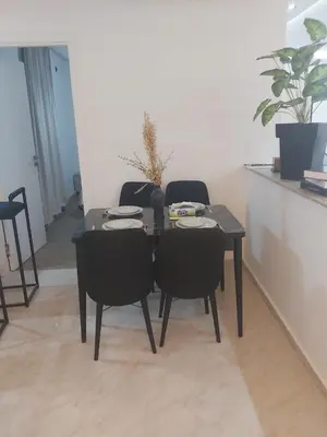 a dining table and chairs in a living room at Centre ville T3 jacuzzi privé 2 min de la gare in Marrakech