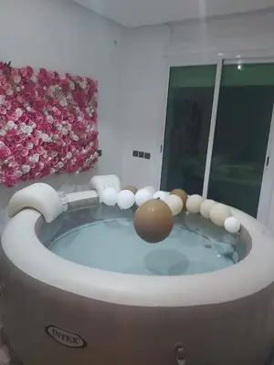 a jacuzzi tub in a bathroom with a flower wall at Centre ville T3 jacuzzi privé 2 min de la gare in Marrakech