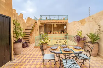 a patio with a table and chairs and stairs at Riad Sharqi Luminous A Sunny in Marrakech Old Town in Marrakech