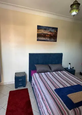 a bedroom with a bed and a painting on the wall at Charmant Appartement à Gueliz - À Deux Pas des Attractions Locales in Marrakech