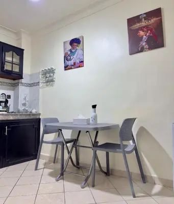 a kitchen with a table and two pictures on the wall at Charmant Appartement à Gueliz - À Deux Pas des Attractions Locales in Marrakech