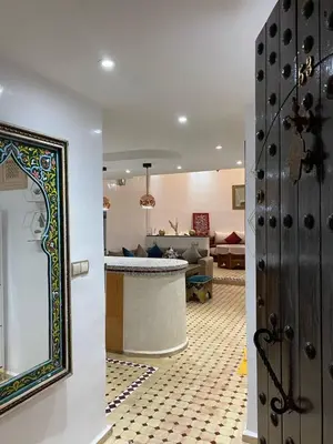 a living room with a bar and a living room with a couch at Riad Camélia in Marrakech