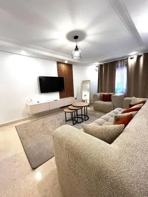 a living room with a couch and a tv at Charmant Appartement à Gueliz in Marrakech