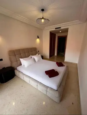 a bedroom with a large white bed with two towels on it at Charmant Appartement à Gueliz in Marrakech