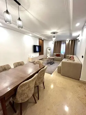 a living room with a large wooden table and chairs at Charmant Appartement à Gueliz in Marrakech