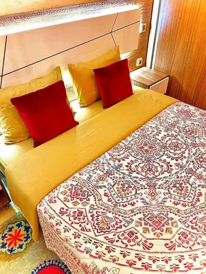 a bedroom with a large bed with two red pillows at Appartement LILIA in Marrakech