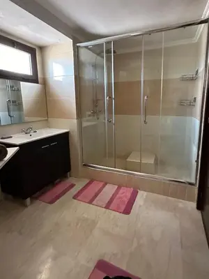 a bathroom with a glass shower and a sink at Luxury Duplex for Rent Suites,terrace,Swimimg Pool in Marrakech