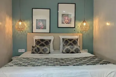 a bedroom with a bed with three pictures on the wall at RoofTop avec Terrasse Centre Gueliz in Marrakech