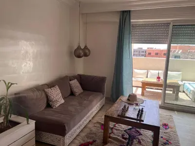 a living room with a brown couch and a table at RoofTop avec Terrasse Centre Gueliz in Marrakech