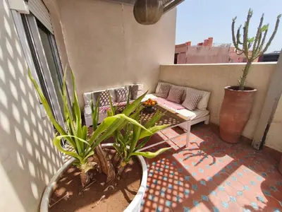 a patio with a couch and plants on a balcony at RoofTop avec Terrasse Centre Gueliz in Marrakech