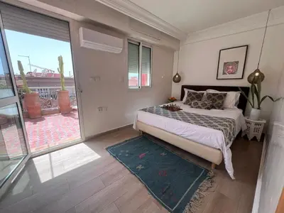 a bedroom with a bed and a large window at RoofTop avec Terrasse Centre Gueliz in Marrakech