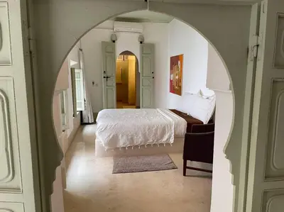 a bedroom with a white bed and an archway at Dar Ibo- Entire House- in Marrakech