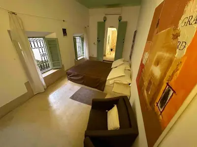 a small room with a bed and a mirror at Dar Ibo- Entire House- in Marrakech