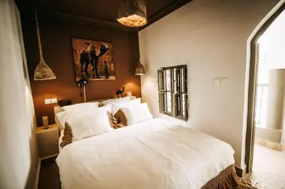 a bedroom with a large bed with white sheets at Riad Shabi Kasbah in Marrakech