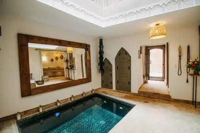 a swimming pool in a house with a large mirror at Riad Shabi Kasbah in Marrakech