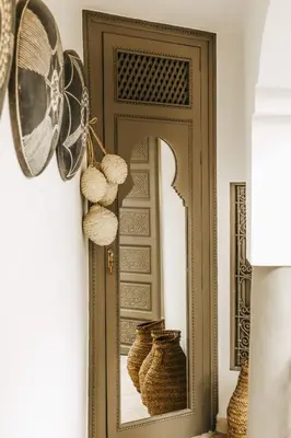 a mirror next to a door with two vases at Riad Shabi Kasbah in Marrakech