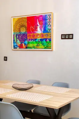a painting hanging on a wall above a wooden table at Appartement en résidence fermée in Marrakech