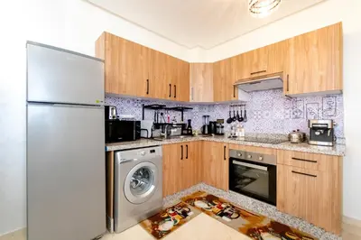 a kitchen with a refrigerator and a dishwasher at Appartement en résidence fermée in Marrakech