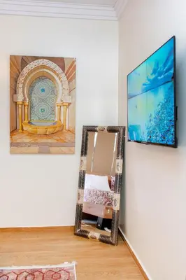 a mirror in a room with a painting on the wall at Appartement en résidence fermée in Marrakech
