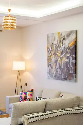 a living room with a couch and a painting on the wall at Appartement en résidence fermée in Marrakech