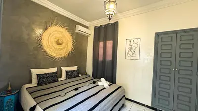 a bedroom with a bed and a chandelier at Riad Beldi Chic Un Séjour Authentique Proche Médina in Marrakech