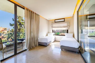 a bedroom with two beds and a large window at Luxury 2 BDR Hivernage in Marrakech