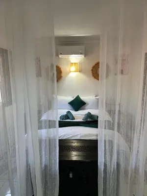 a bedroom with a bed with curtains around it at Riad Nolya Luxury Marrakech - Totalement Rénové - Capacité jusqu à 10 lits spacieux in Marrakech