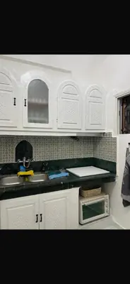 a kitchen with white cabinets and a sink and a microwave at Riad Nolya Luxury Marrakech - Totalement Rénové - Capacité jusqu à 10 lits spacieux in Marrakech