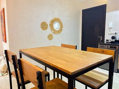 a dining room with a wooden table and chairs at Le Cocon doré avec terrasse ensoleillée au centre de Marrakech in Marrakech
