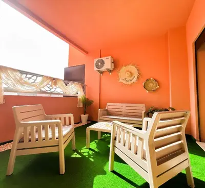 two chairs and a table in a room with orange walls at Le Cocon doré avec terrasse ensoleillée au centre de Marrakech in Marrakech