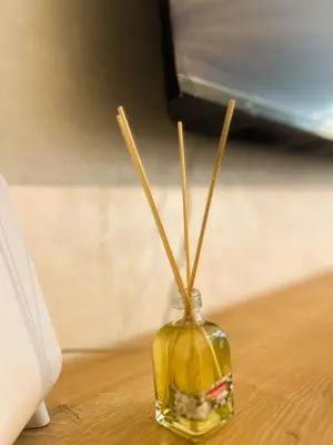 a small glass vase with sticks in it on a table at Le Cocon doré avec terrasse ensoleillée au centre de Marrakech in Marrakech