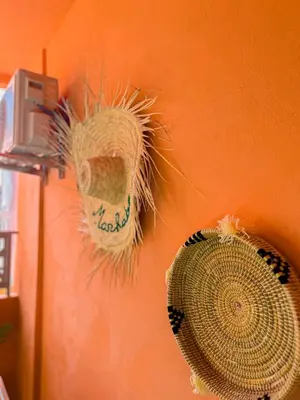 two straw hats and a fan on a wall at Le Cocon doré avec terrasse ensoleillée au centre de Marrakech in Marrakech