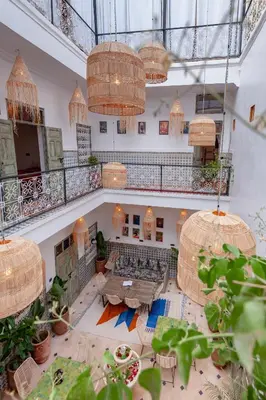 a large room with tables and potted plants in a building at Riad Bab Taghzout Marrakech in Marrakech