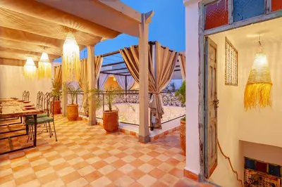 a dining room with a table and a window at Riad Bab Taghzout Marrakech in Marrakech