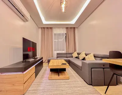 a living room with a couch and a flat screen tv at Luxe et Douceur moderne, Parking Privé in Marrakech