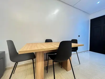 a wooden table and chairs in an empty room at Luxe et Douceur moderne, Parking Privé in Marrakech