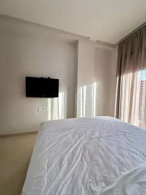a bedroom with a white bed and a flat screen tv at Chambre salon à avenue med 6 centre de gueliz 10 in Marrakech