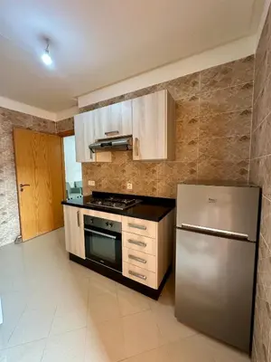 a kitchen with a stainless steel refrigerator and cabinets at Chambre salon à avenue med 6 centre de gueliz 10 in Marrakech