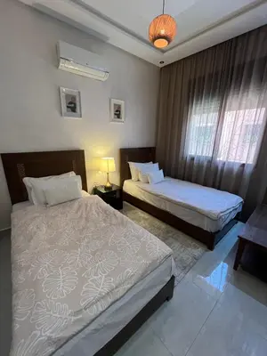 a bedroom with two beds and a window at Dar Amina in Marrakech