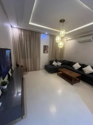 a living room with a black couch and a tv at Dar Amina in Marrakech