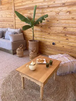 a living room with a coffee table and a plant at Riad DAR OMI ZAHRA in Marrakech