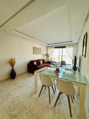 a living room with a glass table and chairs at Spacieux 2 Chambres Guéliz Centre in Marrakech