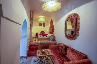 a living room with a couch and a mirror at Riad Yalla habibi in Marrakech