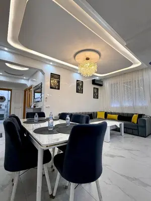 a living room with a table and chairs and a couch at KSYI IMMO 2 Marrakech Aéroport in Marrakech