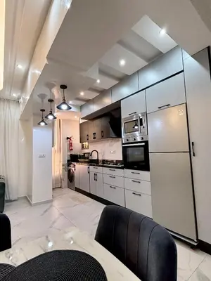 a kitchen with white appliances and a table and chairs at KSYI IMMO 2 Marrakech Aéroport in Marrakech