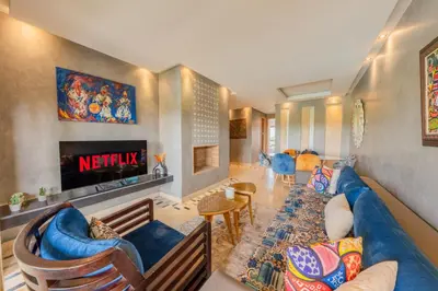 a living room with a blue couch and a tv at Relax Front of Panoraview Pool golf Atlas in Marrakech