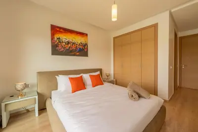 a bedroom with a large white bed with orange pillows at Relax Front of Panoraview Pool golf Atlas in Marrakech