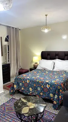 a bedroom with a bed and a table in it at Raid Maison H in Marrakech