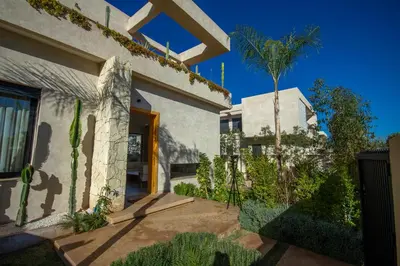 a house with a palm tree in front of it at Villa Piscine Privée, Petit déjeuné et ménage inclus in Marrakech